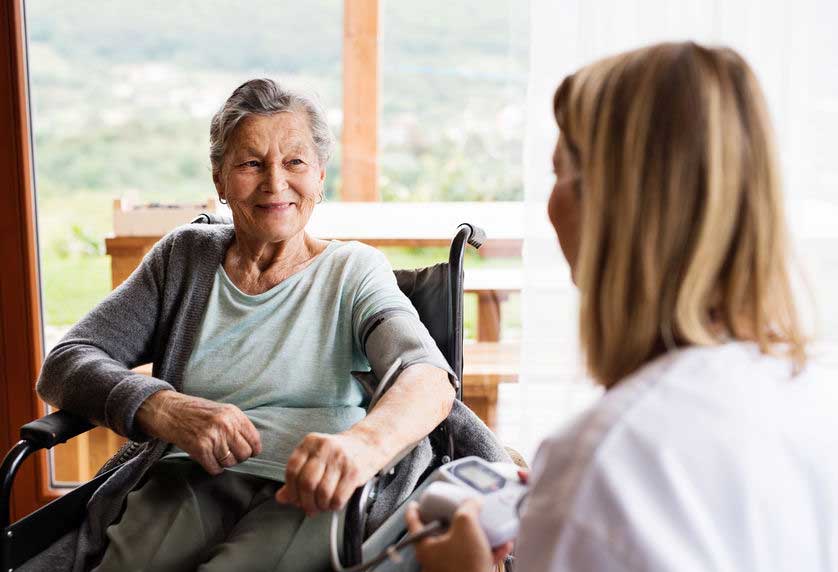 An in-home senior care caregiver visiting with a senior in their home.